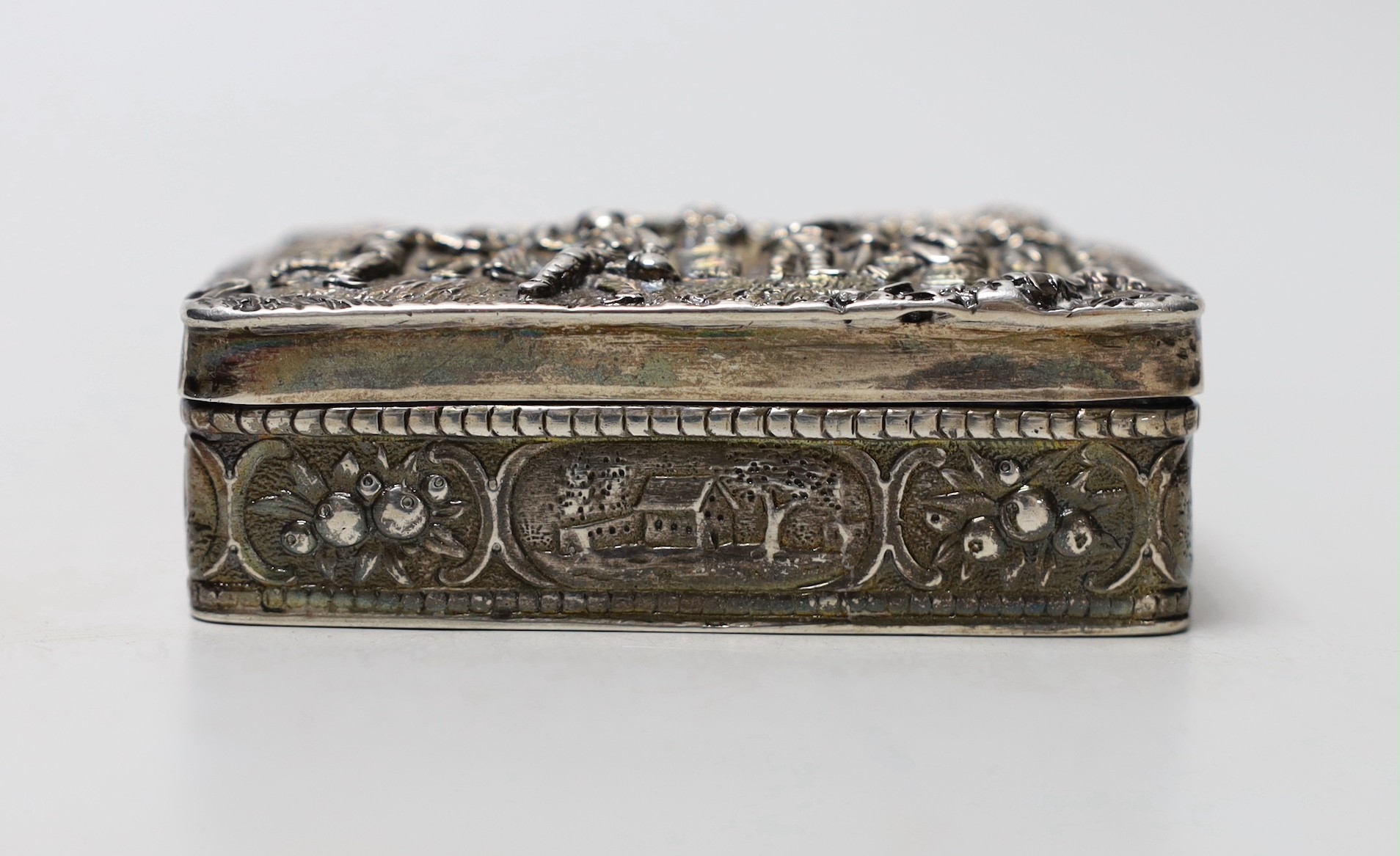 An early 20th century Hanau silver rectangular box, embossed with revellers, import marks for Sheffield, 1900, 87mm.